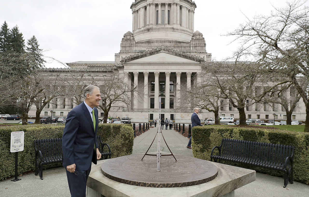 Gov. Jay Inslee stands near the sundial in front of the Legislative Building at the Capitol in Olympia on Jan. 4. (AP Photo/Ted S. Warren, file)
