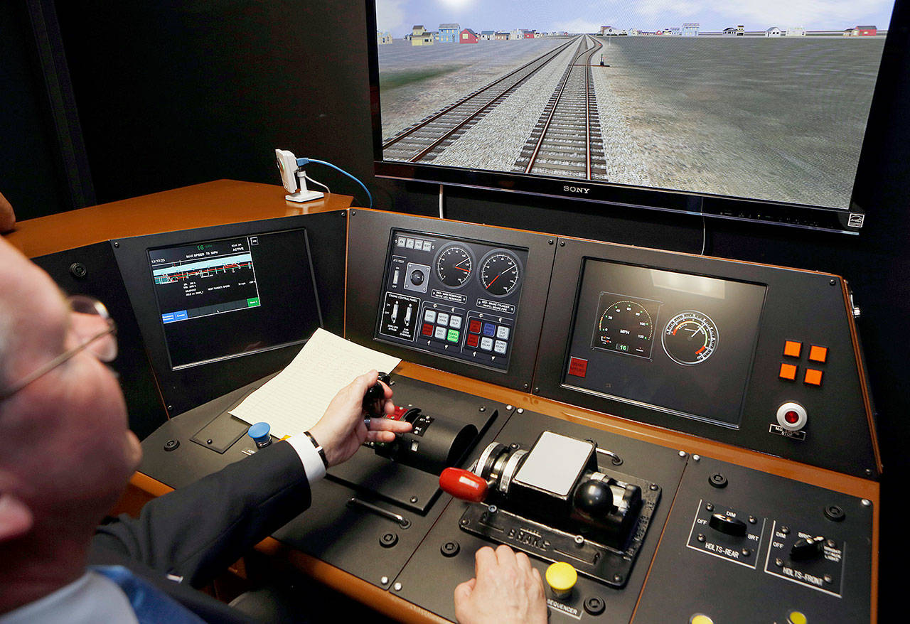 Director of Operations R.T. McCarthy demonstrates Metrolink’s implementation of Positive Train Control (PTC) at the Metrolink Locomotive and Cab Car Simulators training facility in Los Angeles in 2014. (AP Photo/Damian Dovarganes, File)