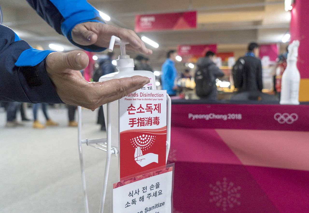 A man sanitizes his hands at the entrance to the media cafeteria in Gangneung, South Korea, on Wednesday. (Paul Chiasson/The Canadian Press via AP)