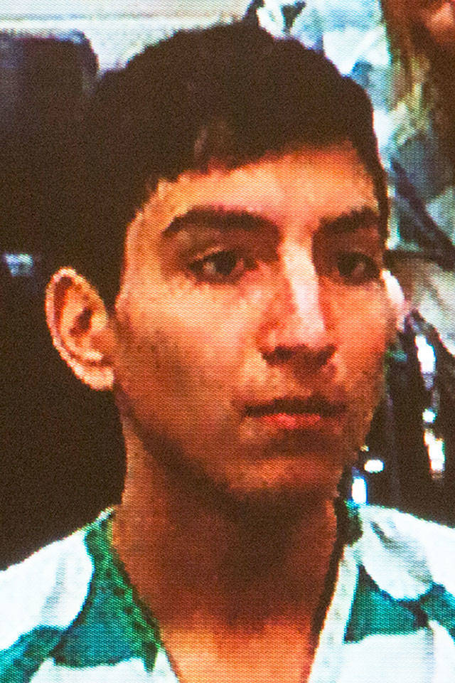Brian Varela is seen on a video monitor during his arraignment on Wednesday in Everett District Court. (Andy Bronson / The Herald)
