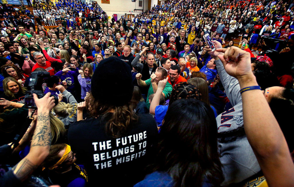 After students from more than three dozen schools danced and visited with one another Tuesday at Marysville Pilchuck High School, which was hosting Interhigh, speaker Mike Smith (center in “future” shirt) asks teachers and staff to come down to the floor and show how it was done in the ‘70s, ‘80s and ‘90s. (Dan Bates / The Herald)
