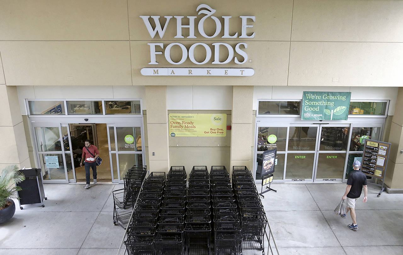 Customers shop at a Whole Foods Market in Tampa, Florida. Amazon plans to roll out two-hour delivery at the organic grocer this year to those who pay for Amazon’s $99-a-year Prime membership. (AP Photo/Chris O’Meara, File)