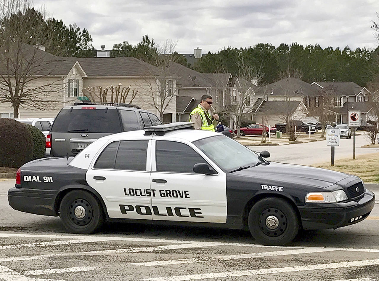 Authorities investigate the scene where multiple law enforcement officers have been shot and a suspect is dead south of Atlanta on Friday in Locust Grove, Georgia. (AP Photo/Jeff Martin)
