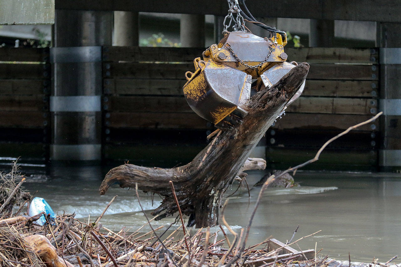 Crews of the Department of Transportation work to clear a log jam on the Ebey Slough at the trestle bridge Wednesday afternoon in Everett on November 22, 2017. (Kevin Clark / The Herald)
