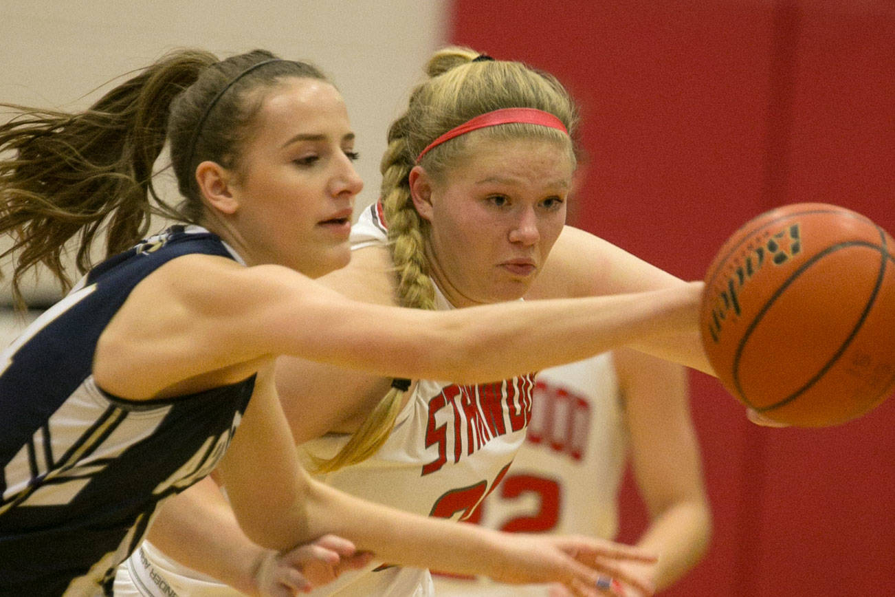 Arlington’s Georgia Arnold (left) and Stanwood’s Kaitlin Larson chase down a loose ball Friday night at Stanwood High School in Stanwood on February 9, 2018. (Kevin Clark / The Daily Herald)