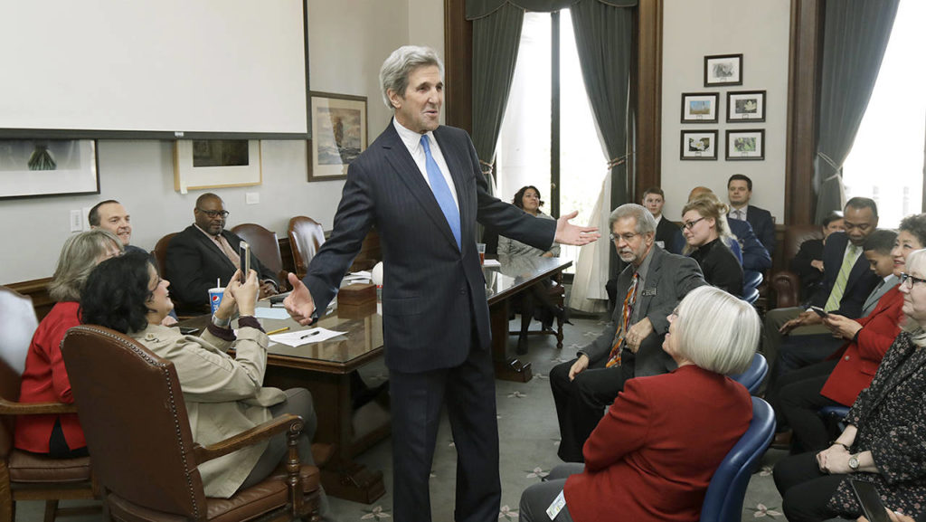 Former U.S. Secretary of State John Kerry greets members of the Washington State House Democratic Caucus on Tuesday. (Ted S. Warren / Associated Press)
