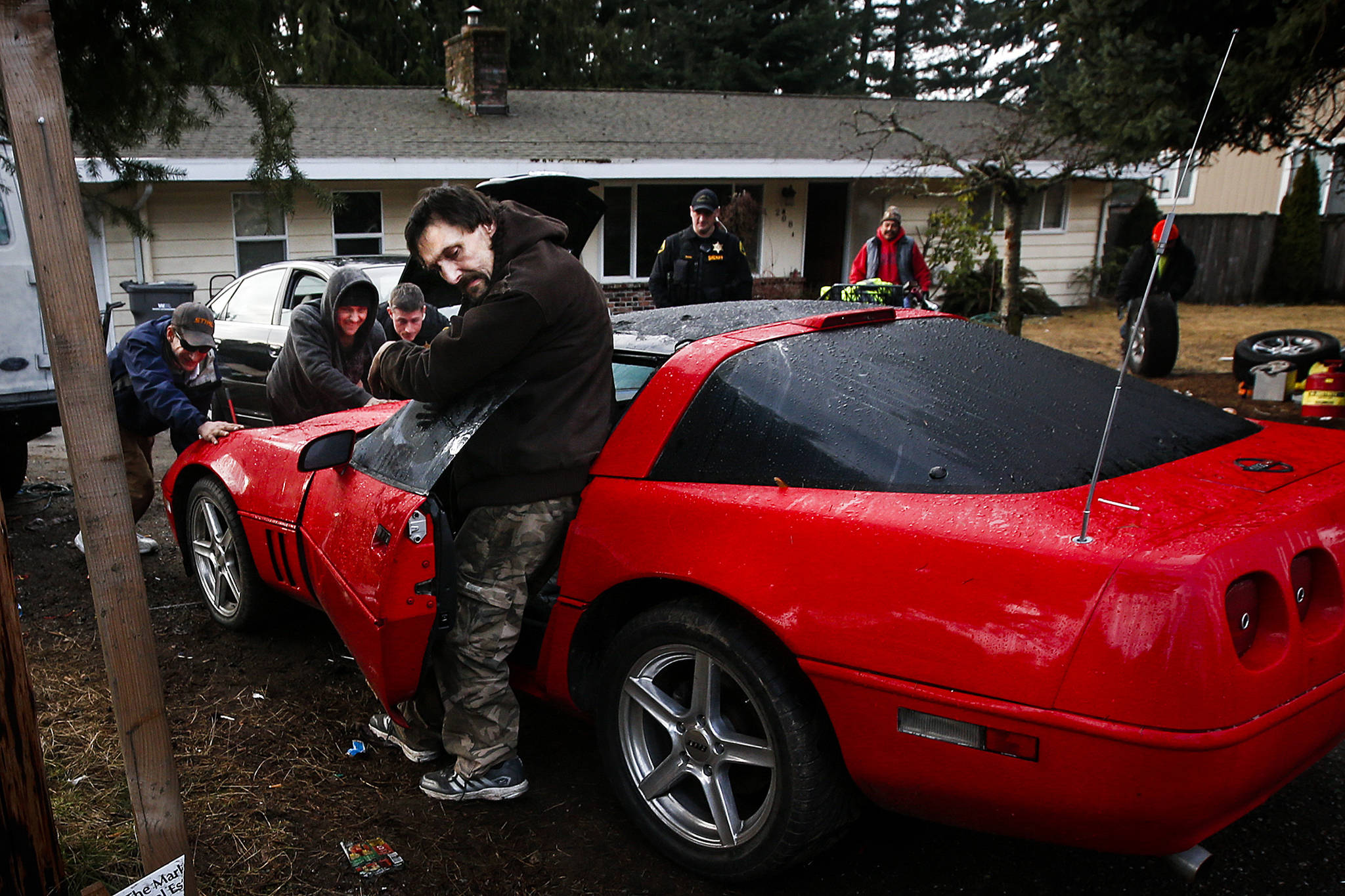 A Chevrolet Corvette that wouldn’t start is rolled out of the driveway of an Everett home occupied by as many as 21 squatters. They were served with eviction notices in 2017. (Ian Terry / Herald file)