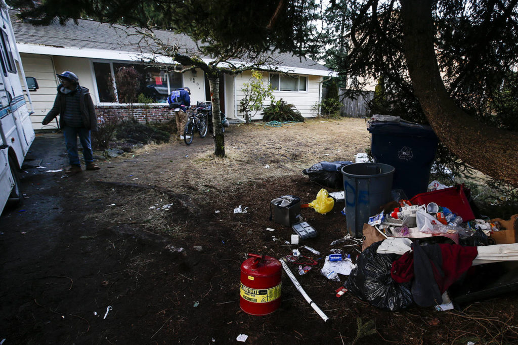 Trash is strewn about the front yard of a home used by squatters in Everett in 2017. (Ian Terry / Herald file)
