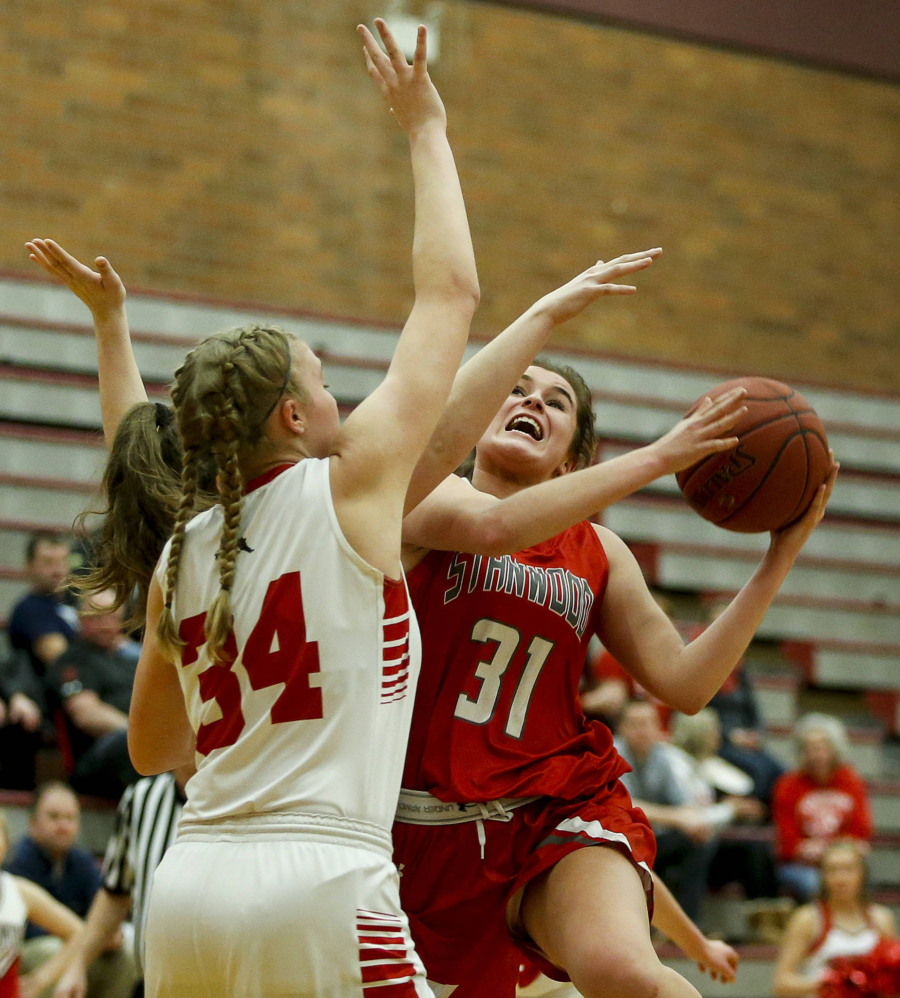 Stanwood’s Madison Chisman (31) takes a shot as Snohomish’s Kyra Beckman defends during a playoff game on Feb. 13, 2018, at Mountlake Terrace High School. (Ian Terry / The Herald)