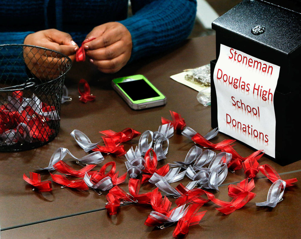 At EvCC’s Student Life office, diversity and engagement coordinator Katina Brown makes ribbon pins for people who donate to a fund to help victims of the Stoneman Douglas High School shooting. (Dan Bates / The Herald)

