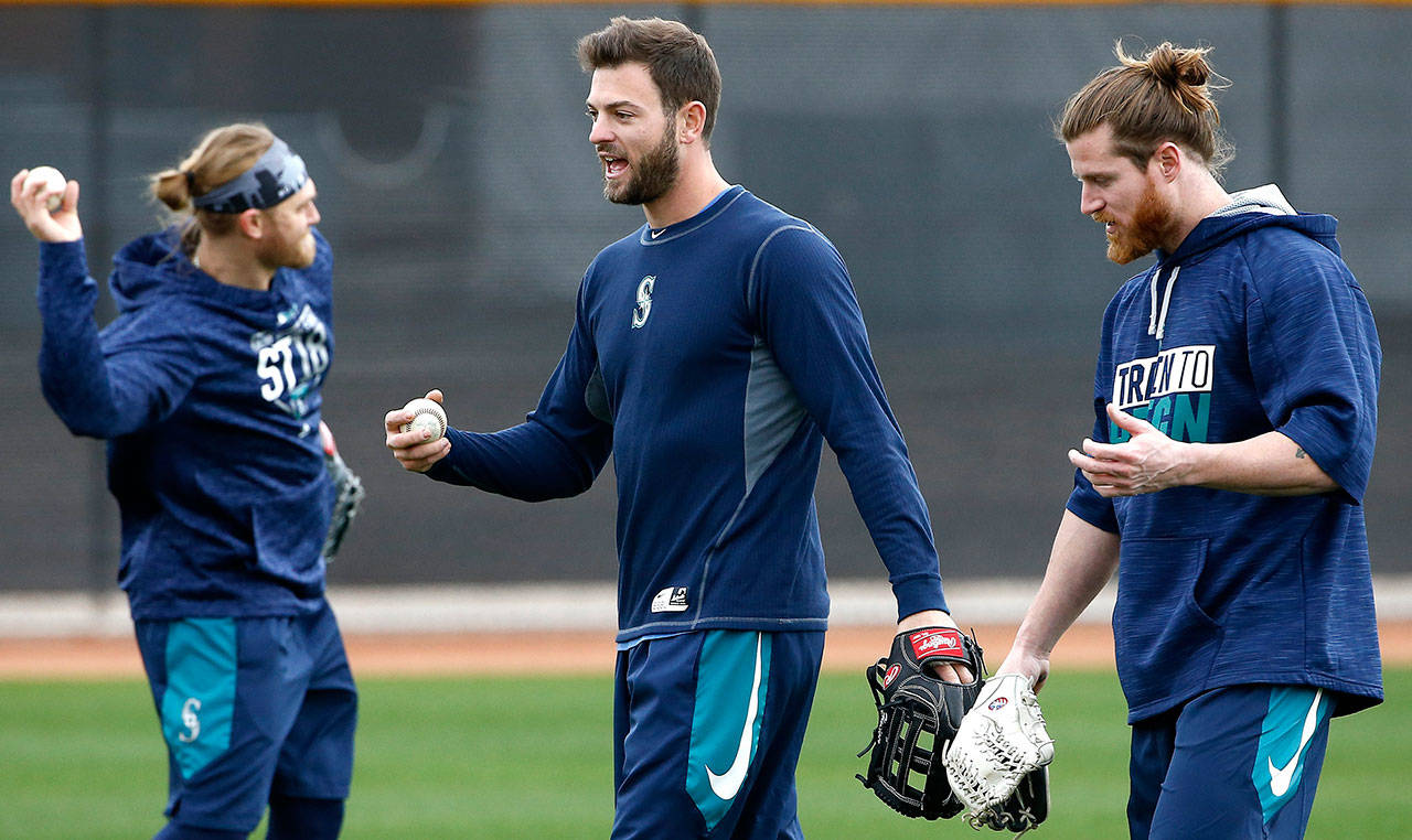 The Mariners’ Mitch Haniger (center) talks with Ben Gamel (right) as Taylor Motter (left) throws a baseball during an informal workout at Seattle’s spring training complex on Feb. 14, 2018, in Peoria, Ariz. (AP Photo/Ross D. Franklin)