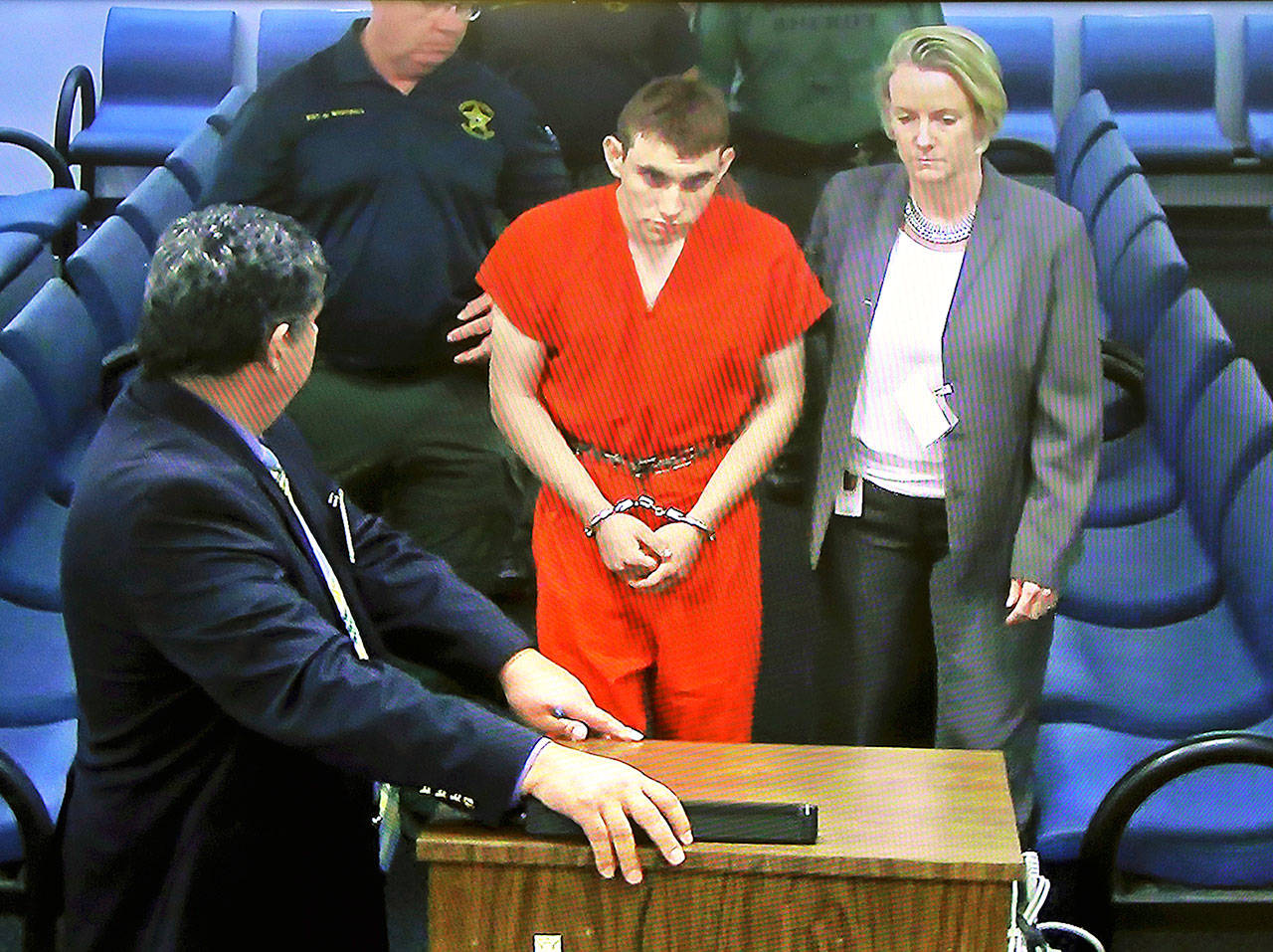 A video monitor shows school shooting suspect Nikolas Cruz (left) with public defender Melisa McNeille making an appearance in Broward County Court on Thursday, in Fort Lauderdale, Florida. (Susan Stocker/South Florida Sun-Sentinel via AP, Pool)