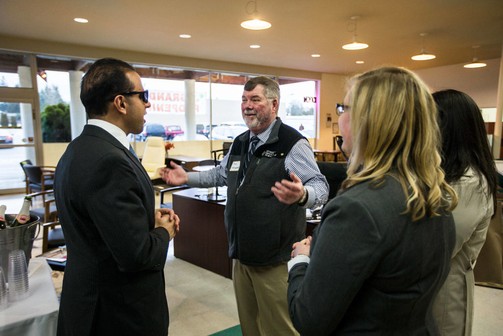 Owner Brian Hollingshead (center) with Lt. Gov. Cyrus Habib (left) and other well-wishers at the Jan. 25 grand opening of Everett Office Furniture, four months after the store burned down. The business was able to get up and running four days after the fire because all the crucial paperwork inside the safe survived. (Andy Bronson / The Herald)
