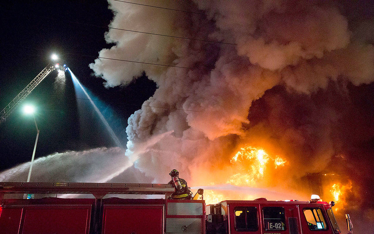 Firefighters pour water on a three-alarm fire at Everett Office Furniture on Broadway on Sept. 25, 2017, in Everett. The fire caused damage estimated at $1.5 million. (Andy Bronson / Herald file)