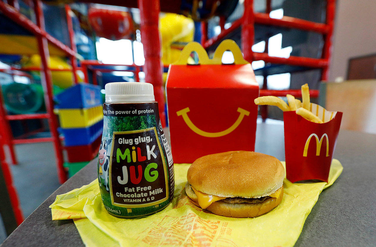 A Happy Meal featuring non-fat chocolate milk and a cheeseburger with fries, are arranged for a photo at a McDonald’s restaurant in Brandon, Miss., Wednesday. McDonald’s will soon banish cheeseburgers and chocolate milk from its Happy Meal menu. Diners can still ask specifically for cheeseburgers or chocolate milk with the kid’s meal, but the fast-food company said that not listing them will reduce how often they’re ordered. (AP Photo/Rogelio V. Solis)