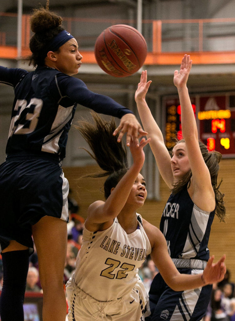 Lake Stevens’ Raigan Reed (center) attempts a shot with Glacier Peak’s Alexyss Newman (left) and Nicole Jensen defending during the 4A district championship on Feb. 15, 2018, at Everett Community College. (Kevin Clark / The Herald)
