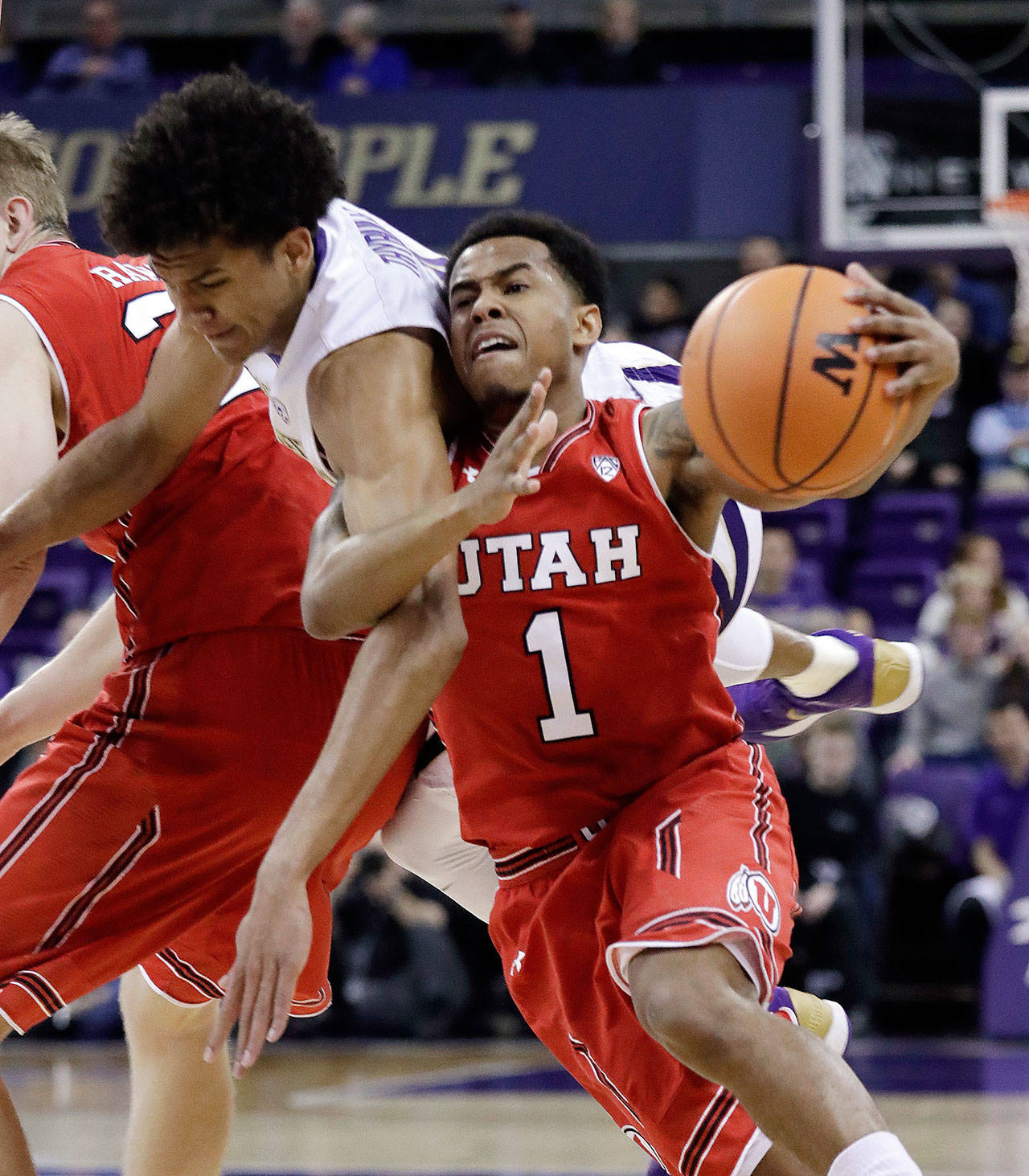 Washington’s Matisse Thybulle (center) flips up behind Utah’s Justin Bibbins (1) after being fouled by Tyler Rawson (left) during the first half of a game Feb. 15, 2018, in Seattle. (AP Photo/Elaine Thompson)