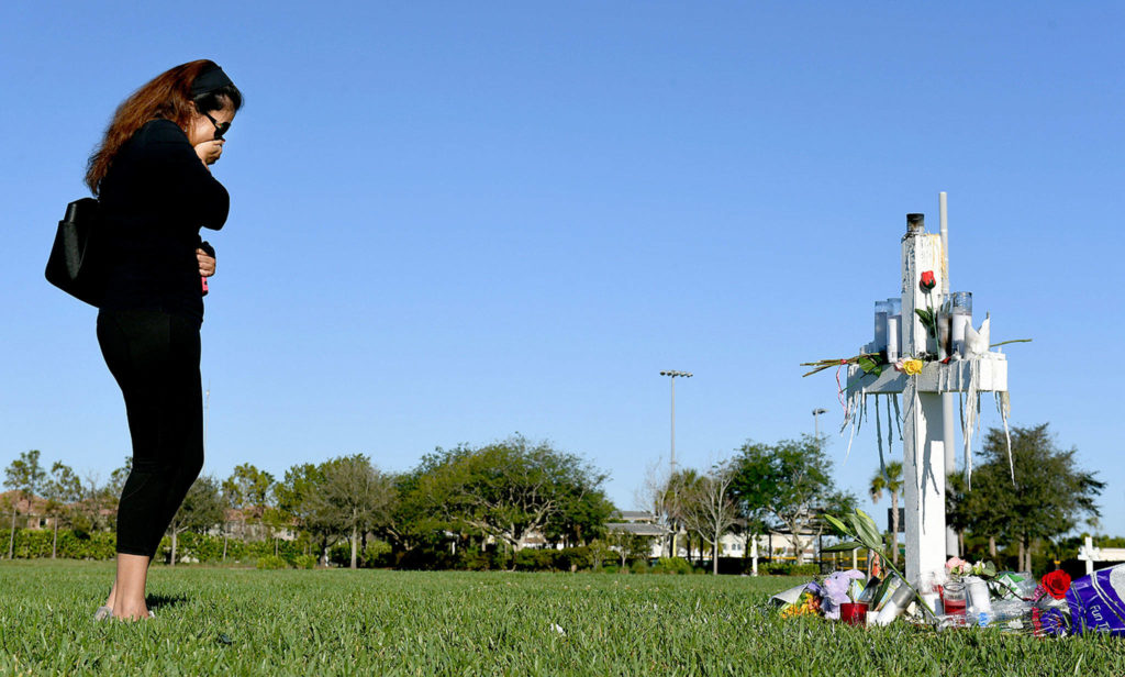 Katiusca Dulski cries as she visits a makeshift memorial on Friday in Pine Trails Park for the victims of the Marjory Stoneman Douglas High School shooting in Parkland, Florida. There was a cross in the park for each victim. (Matt McClain / Washington Post)
