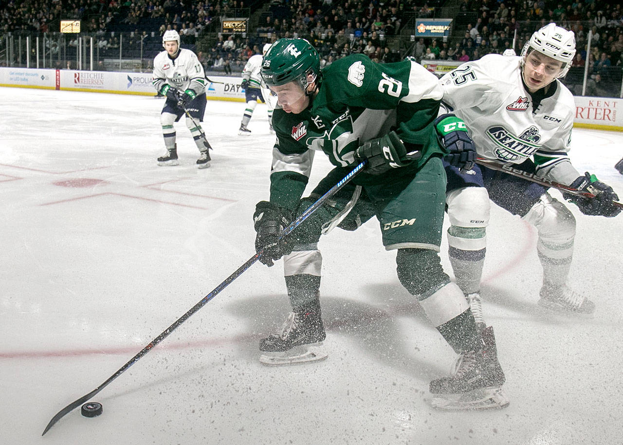 Everett’s Reece Vitelli controls the puck with Seattle’s Owen Williams trailing in the first period at the Showare Center Friday night in Kent February 16, 2018. (Kevin Clark / The Daily Herald)
