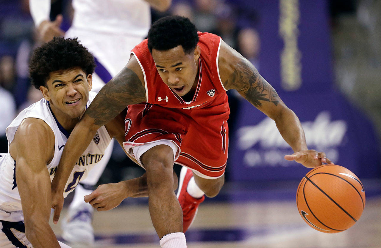 Utah’s Justin Bibbins (right) dribbles the ball as Washington’s Matisse Thybulle stumbles to the floors during the second half of a game Feb. 15, 2018, in Seattle. Utah won 70-58. (AP Photo/Elaine Thompson)