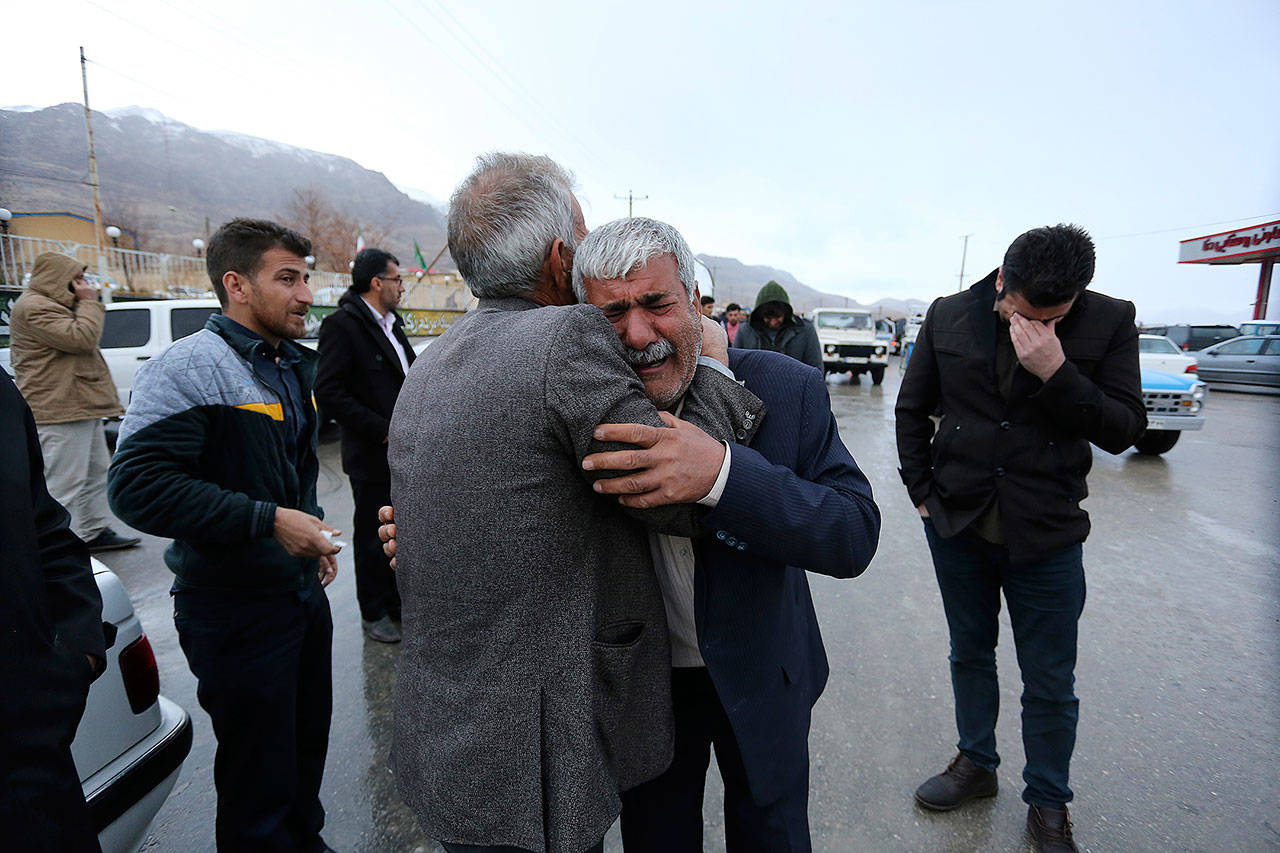 In this photo provided by Tasnim News Agency, family members of a plane crash victims weep in the village of Bideh, at the area that the plane crashed, southern Iran, Sunday. An Iranian commercial plane crashed Sunday in a foggy, mountainous region of southern Iran, and officials said they feared all people aboard were killed. (Ali Khodaei/Tasnim News Agency via AP)