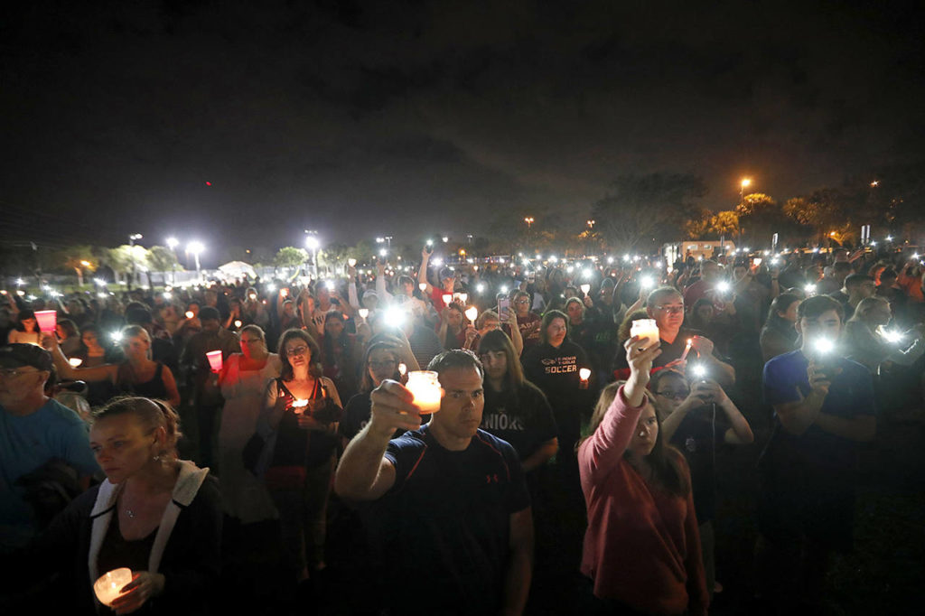People participate in a candlelight vigil in memory of the 17 students and faculty who were killed in the Wednesday mass shooting at Marjory Stoneman Douglas High School in Parkland, Florida, on Monday. (AP Photo/Gerald Herbert)
