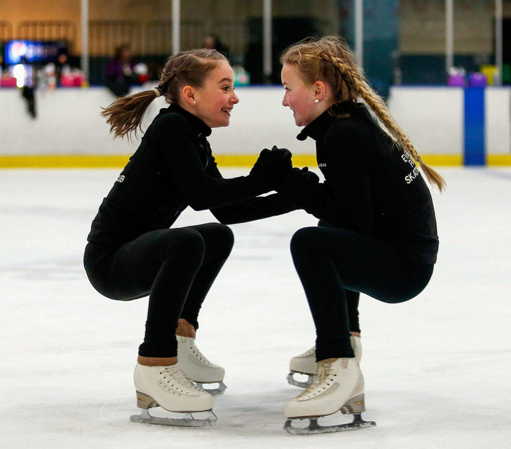 In Susannah Hall McAllister’s Everett Figure Skating Club class, students Maddie Grace Moore, 10 (left) and Logan Stephenson, 10, hold hands and skate in circles. (Dan Bates / The Herald)
