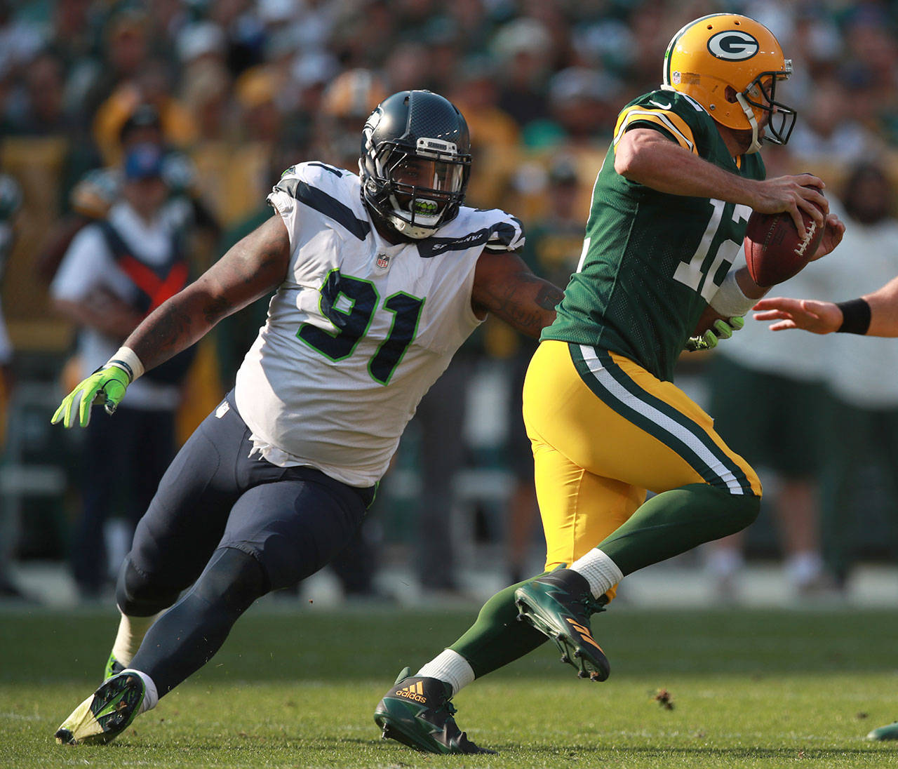 Seahawks defensive tackle Shledon Richardson (left) pressures Packers quarterback Aaron Rodgers (12) during a game on Sept. 10, 2017, in Green Bay, Wis. (Jeff Haynes/AP Images for Panini)