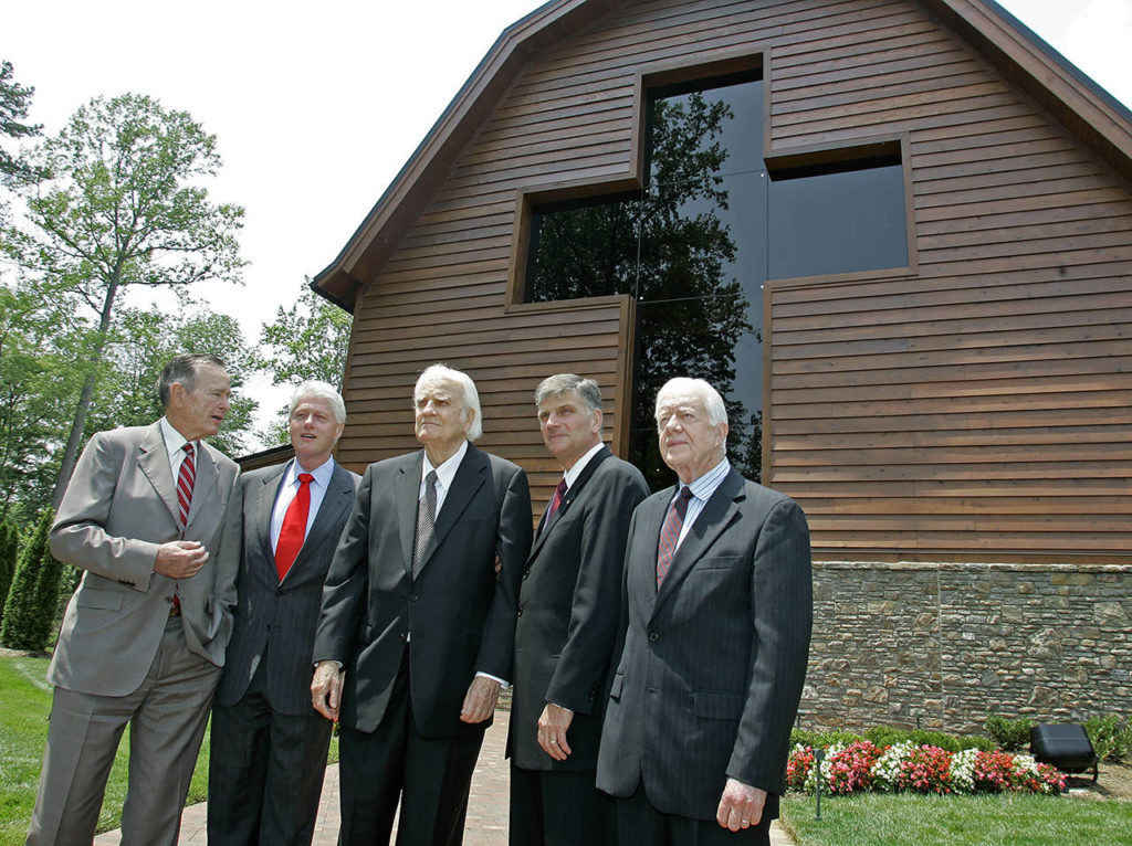 In this May 31, 2007 photo, former Presidents George H.W. Bush (left), Bill Clinton (second left) and Jimmy Carter (right) join Franklin Graham (second right) as they pose with Billy Graham (center) in front of the Billy Graham Library in Charlotte, North Carolina. (AP Photo/Chuck Burton, File)
