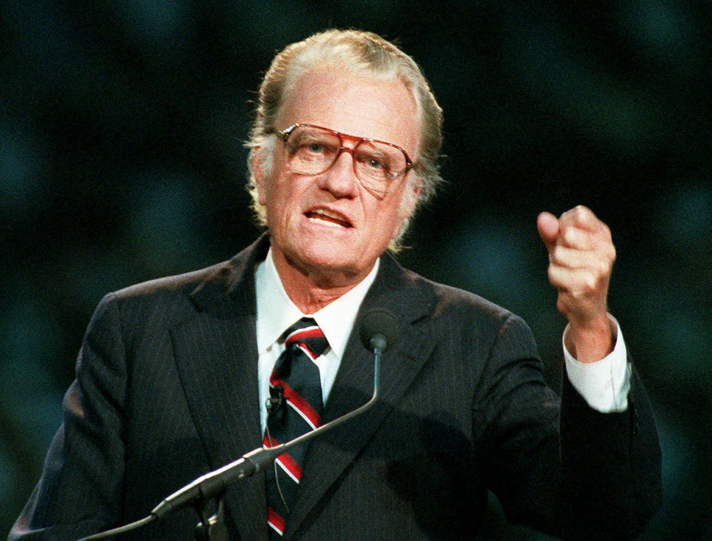 In this Oct 26, 1994 photo, Evangelist Billy Graham begins his sermon in Atlanta’s Georgia Dome. Graham, who transformed American religious life through his preaching and activism, becoming a counselor to presidents and the most widely heard Christian evangelist in history, has died. He was 99. (AP Photo/John Bazemore, File)
