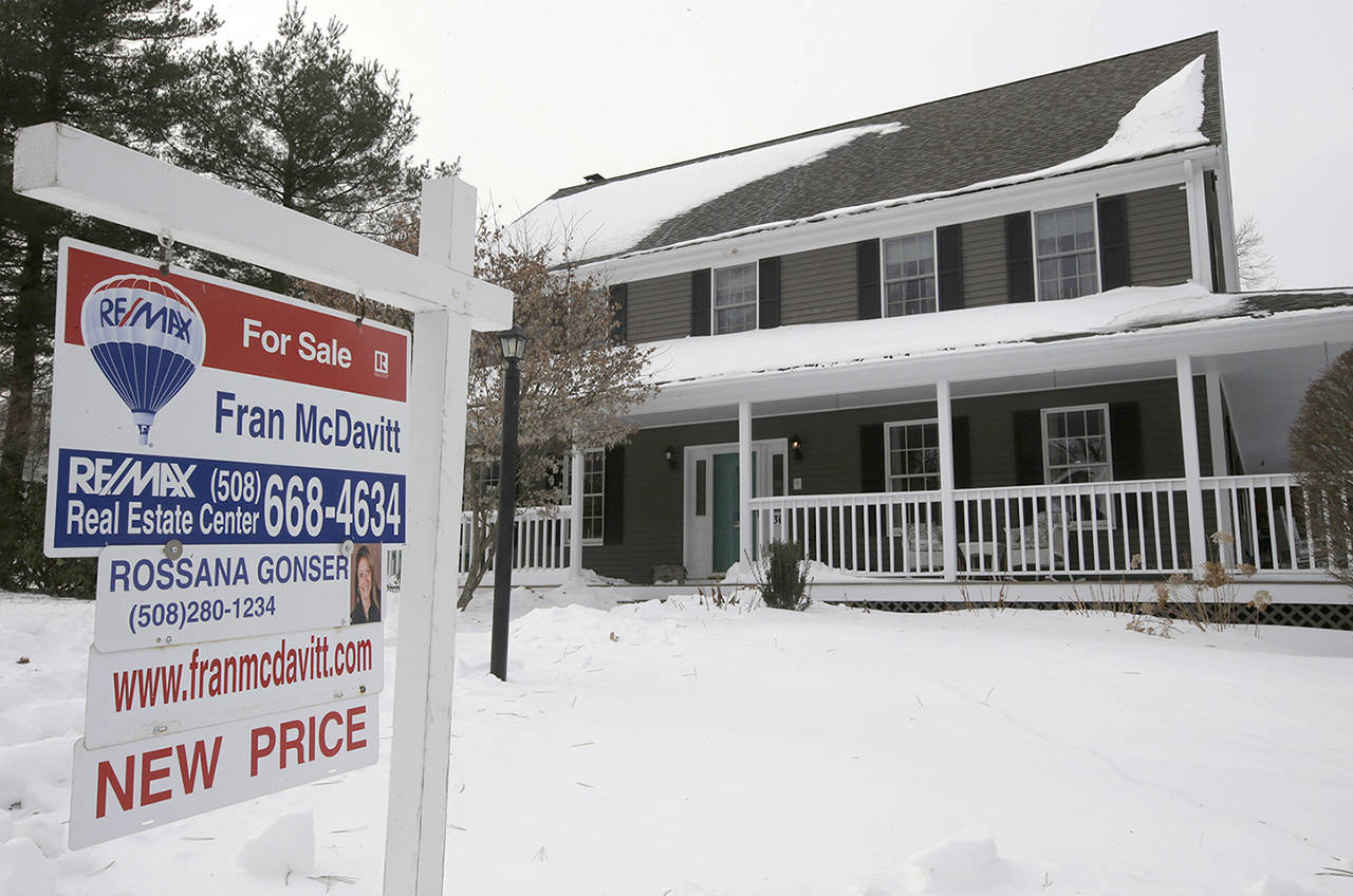 In this Monday photo, a real estate for sale sign hangs in front of an existing home in Walpole, Massachusetts. (AP Photo/Steven Senne)