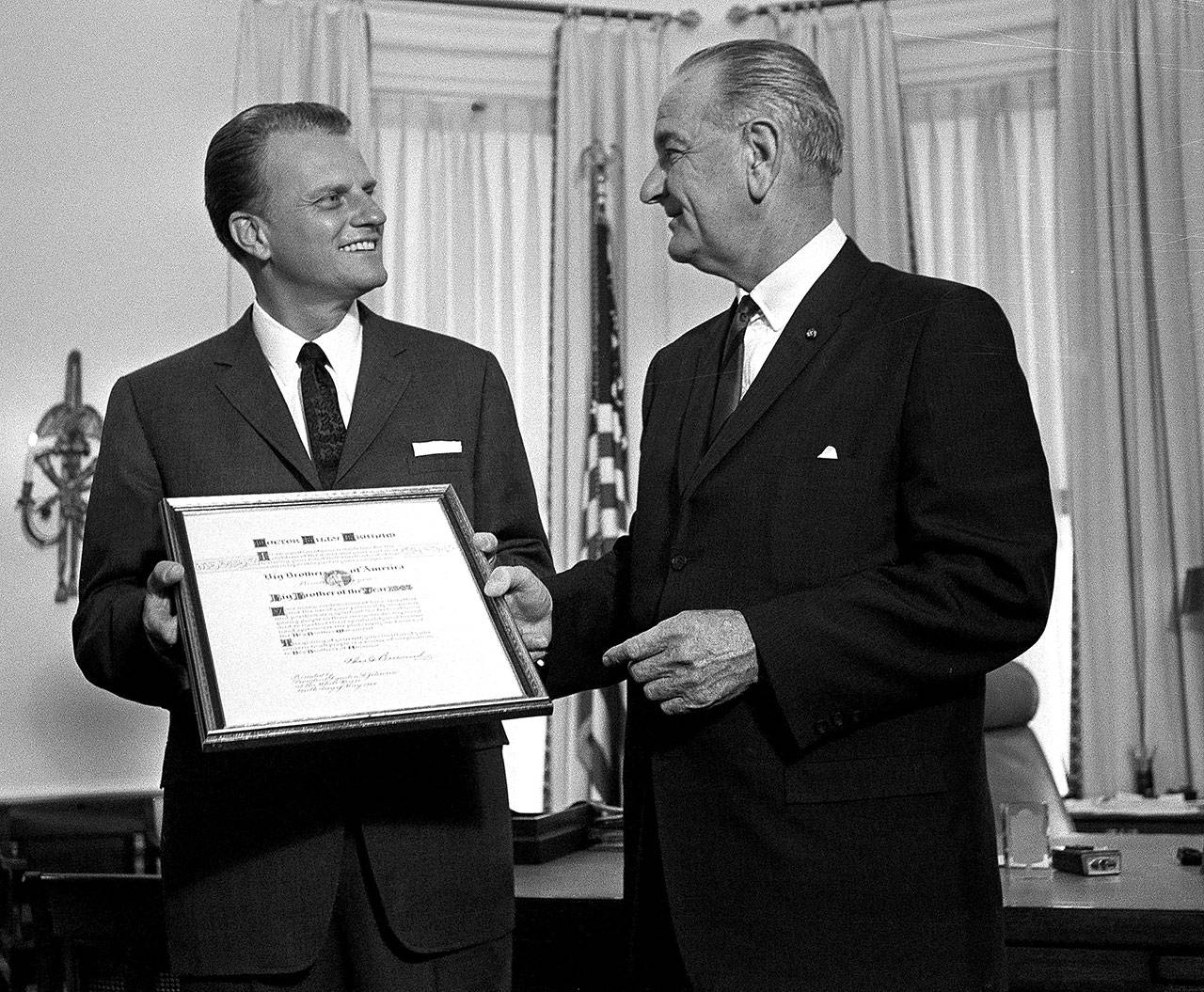 President Lyndon Johnson presents the Man of the Year award of the Big Brothers organization to evangelist Billy Graham at the White House in Washington, D.C., in May, 1966. Graham, who transformed American religious life through his preaching and activism, becoming a counselor to presidents and the most widely heard Christian evangelist in history, died Wednesday at the age of 99. (Associated Press file photo)