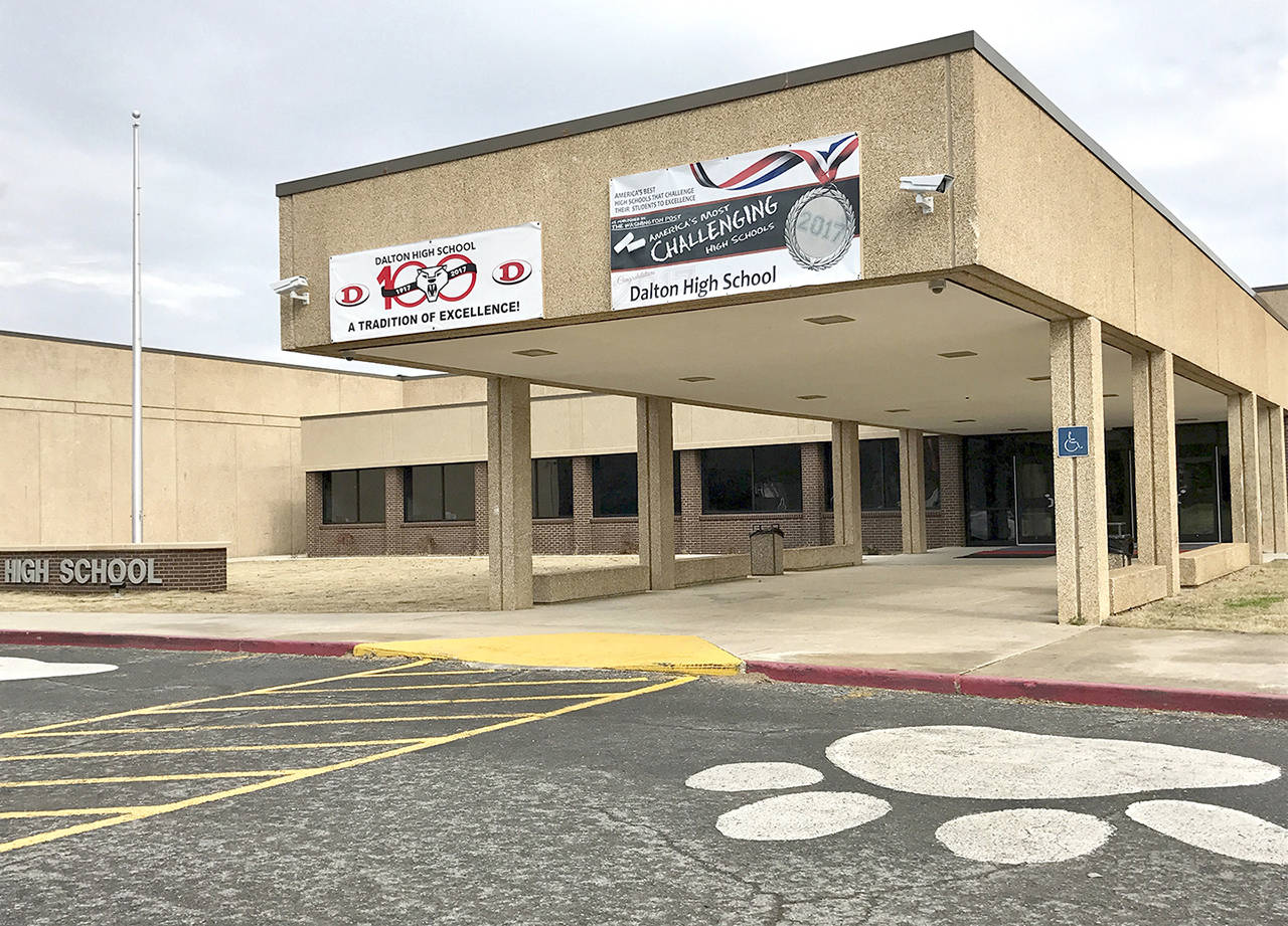 Police in Georgia say officers are responding to reports of shots fired at Dalton High School and a teacher who may have been barricaded in a classroom is in custody. (AP Photo/Jeff Martin)