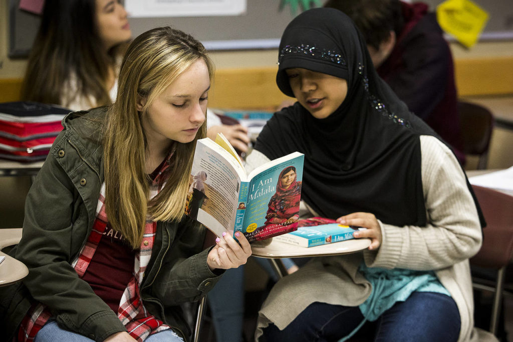 Cascade High School students Ashlyn Murphy (left) and Rosita Rasyid discuss a passage of Malala Yousafzai’s book “I Am Malala” during one of Jennifer Dow Himstedt’s sophomore English classes at the Everett school on Feb. 27. (Ian Terry / The Herald)
