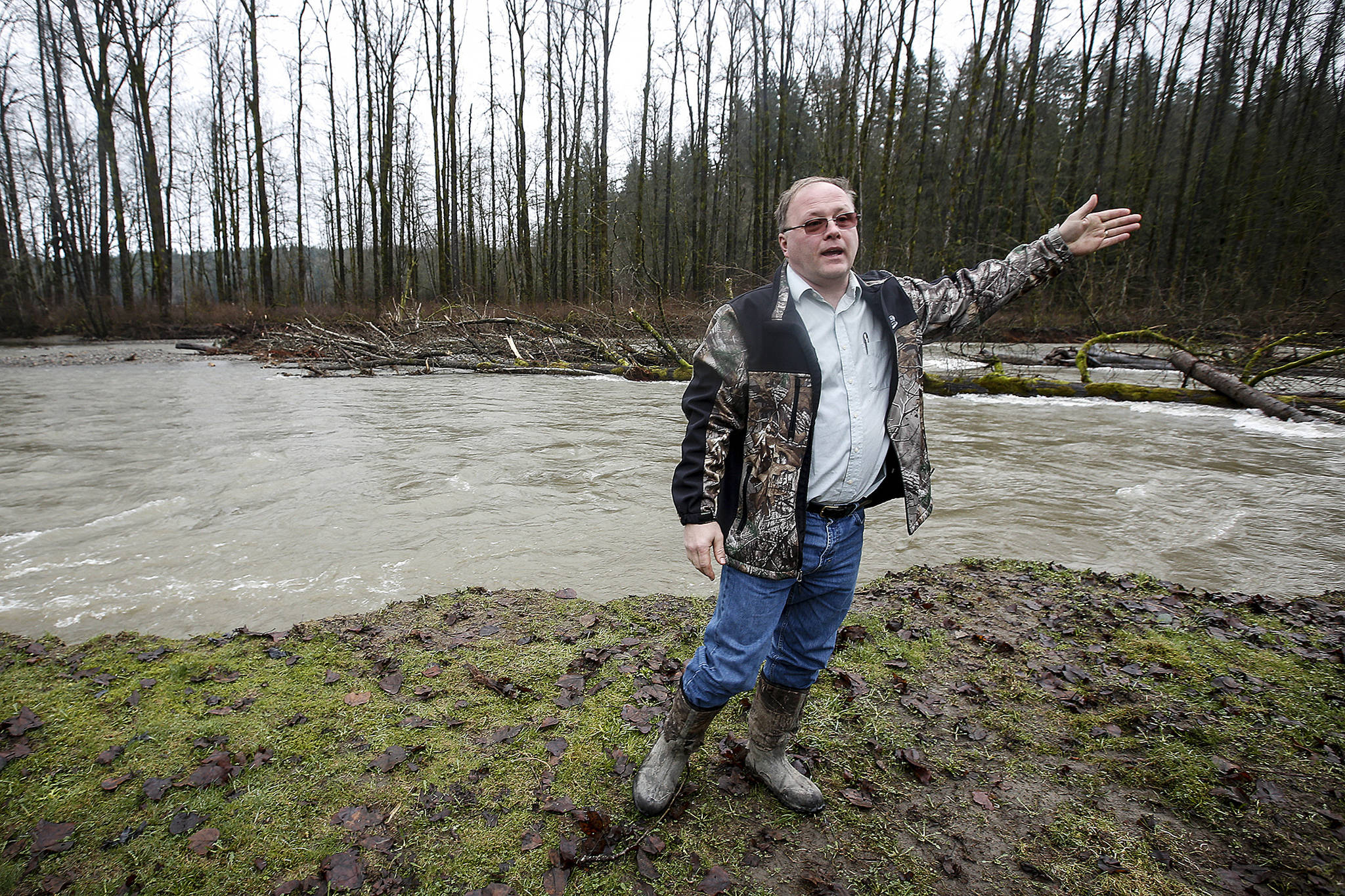 Marek Novy stands on his property, between Lake Stevens and Granite Falls, on Tuesday, Feb. 6. The Pilchuck River is eating away at Novy’s land which used to extend to where downed trees in the river can be seen now. (Ian Terry / The Herald)