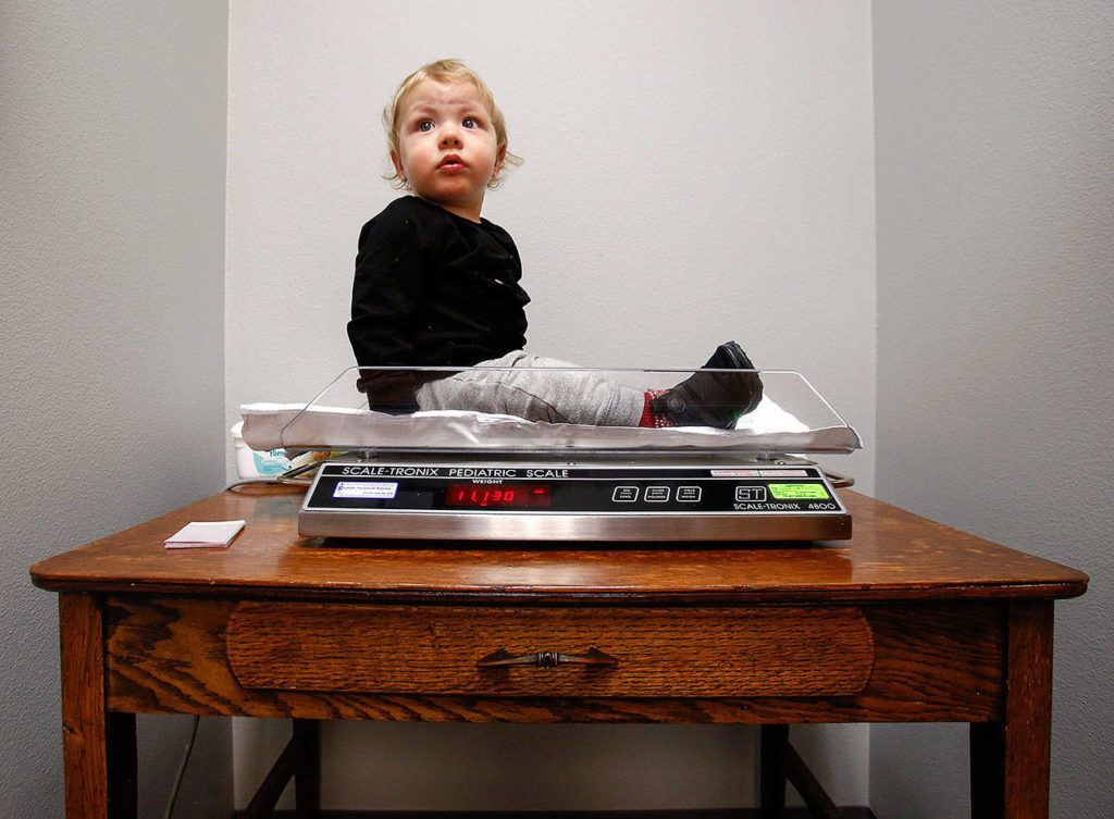 At Pacific Wellness and Lactation, Braylon Machado, 1, waits a moment for his mom and caregiver BreAnne Marcucci to check his weight on a pediatric scale. (Dan Bates / The Herald)
