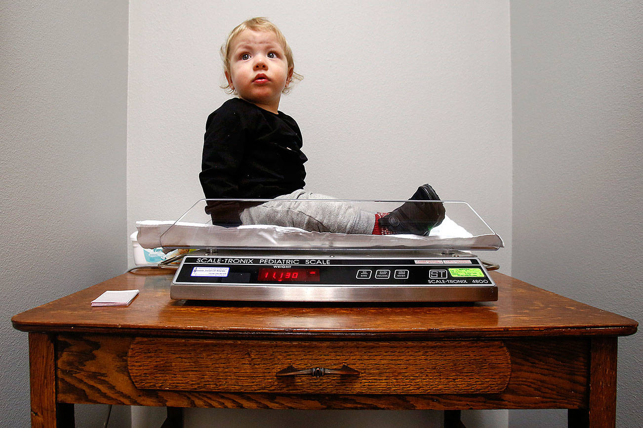 At Pacific Wellness and Lactation, Braylon Machado, 1, waits a moment for his mom and caregiver BreAnne Marcucci to check his weight on a pediatric scale. (Dan Bates / The Herald)