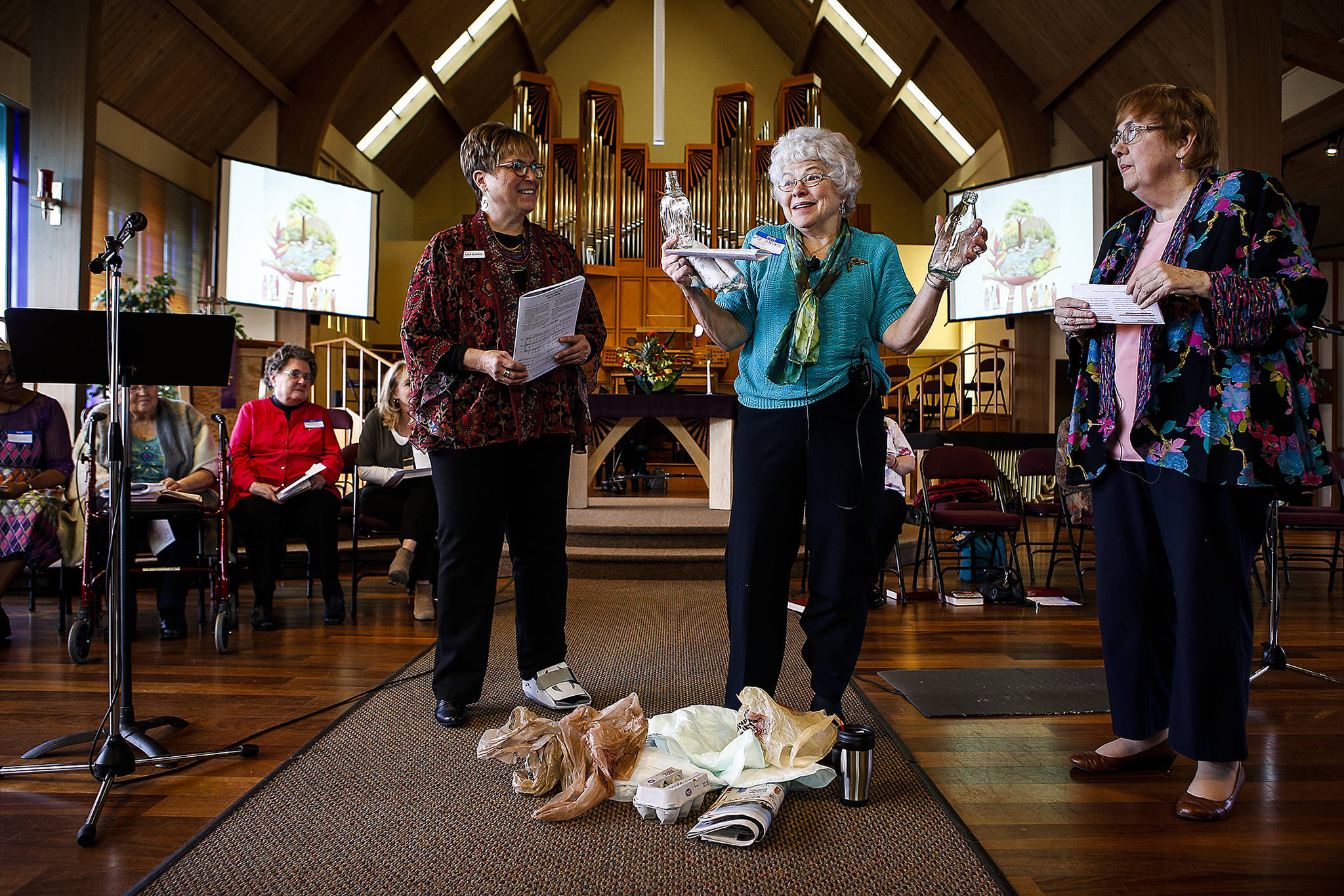 Jeannine Lish (center) performs a skit about recycling with the help of friends Lisa Burns (left) and Elaine Salisbury during a ceremony held at Edmonds United Methodist Church in celebration of the World Day of Prayer on March 2. (Ian Terry / The Herald)