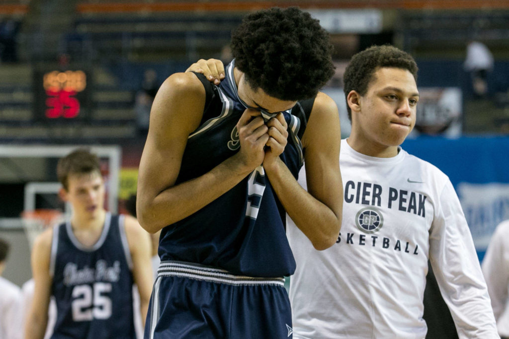 Glacier Peak’s Trey Lawrence (left) is comforted by teammate Tony Collins after loosing to Skyview High in the WIAA state basketball tournament Wednesday at the Tacoma Dome in Tacoma on February 28, 2018. (Kevin Clark / The Daily Herald)
