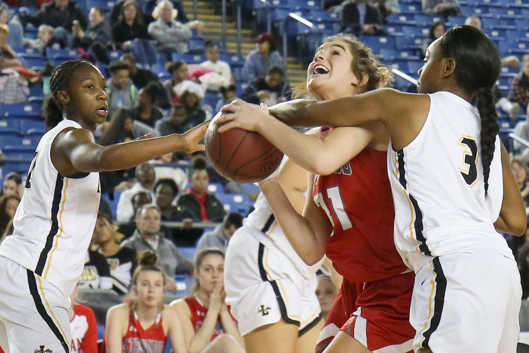 Stanwood’s Madison Chisman attempts a shot and is fouled by Lincoln’s Nashontae Frazier (right) with Lincoln’s Kondalia Montgomery (left) looking during the WIAA state basketball tournament Wednesday at the Tacoma Dome in Tacoma on March 1, 2018. (Kevin Clark / The Daily Herald)