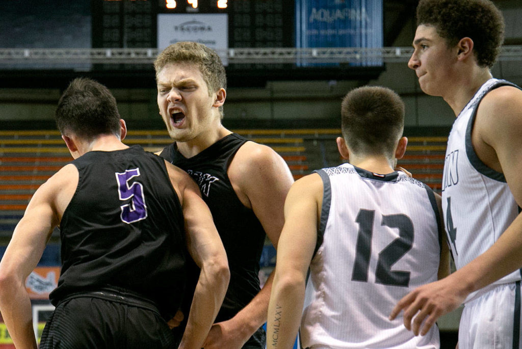 Kamiak’s Patrick Olson (5) gets a celebratory bump form teammate Landon Overturf with Union’s Tyler Combs (12) and Union’s Jason Franklin Jr. during the WIAA state basketball tournament Wednesday at the Tacoma Dome in Tacoma on February 28, 2018. (Kevin Clark / The Daily Herald)