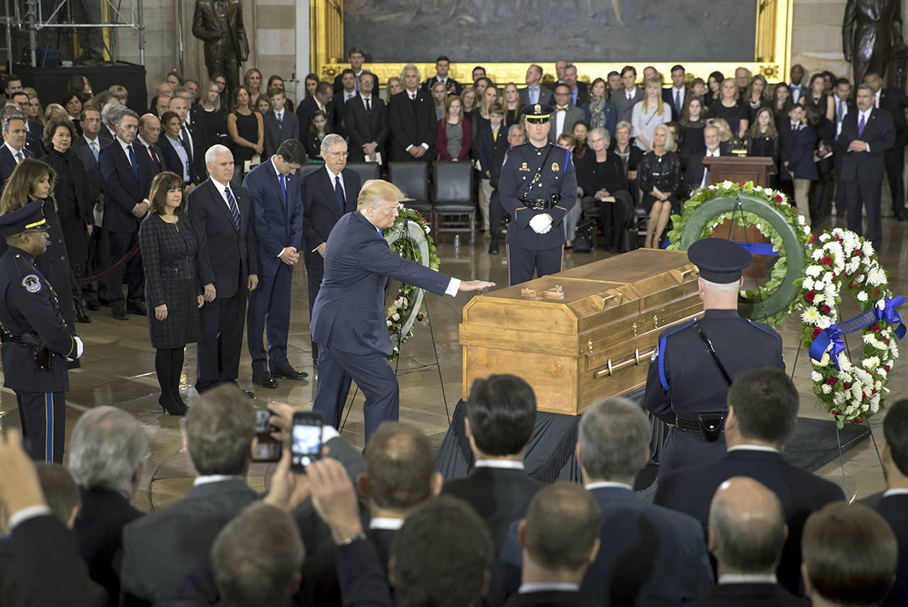President Donald Trump touches the casket of Rev. Billy Graham during a Wednesday ceremony in the Capitol Rotunda where he will lie in honor as a tribute to America’s most famous evangelist. (AP Photo/J. Scott Applewhite)