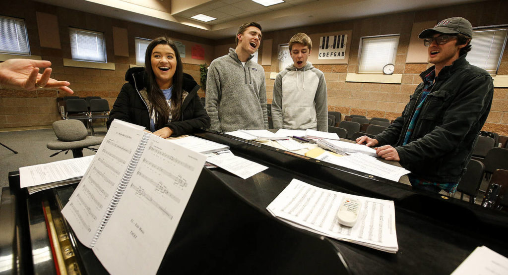 Under the direction of music director Nancy Duck-Jefferson (not pictured), Kamiak High School students (from left)Kennedy Miller, Aidan Norris, Gavin McKeever and Mitchell Beard rehearse the song “Always Look On The Bright Side of Life” from “Spamalot.”(Ian Terry / The Herald)

