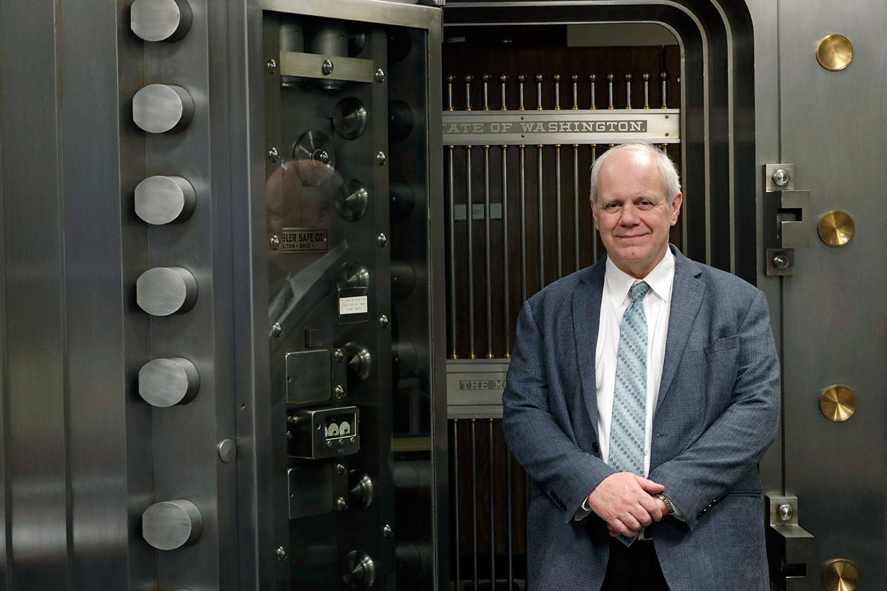 Washington State Treasurer Duane Davidson, standing in front of a state vault on Feb. 22, at the Capitol in Olympia, wants lawmakers to use some of an expected $1.3 billion revenue windfall to pay down the state’s growing debt. (Ted S. Warren / Associated Press)