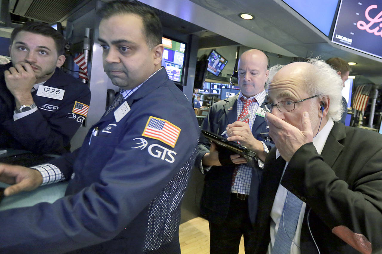 Specialists Matthew Grenier (left) and Dilip Patel (second left) work with traders Patrick Casey (third left) and Peter Tuchman on the floor of the New York Stock Exchange on Friday. (AP Photo/Richard Drew)