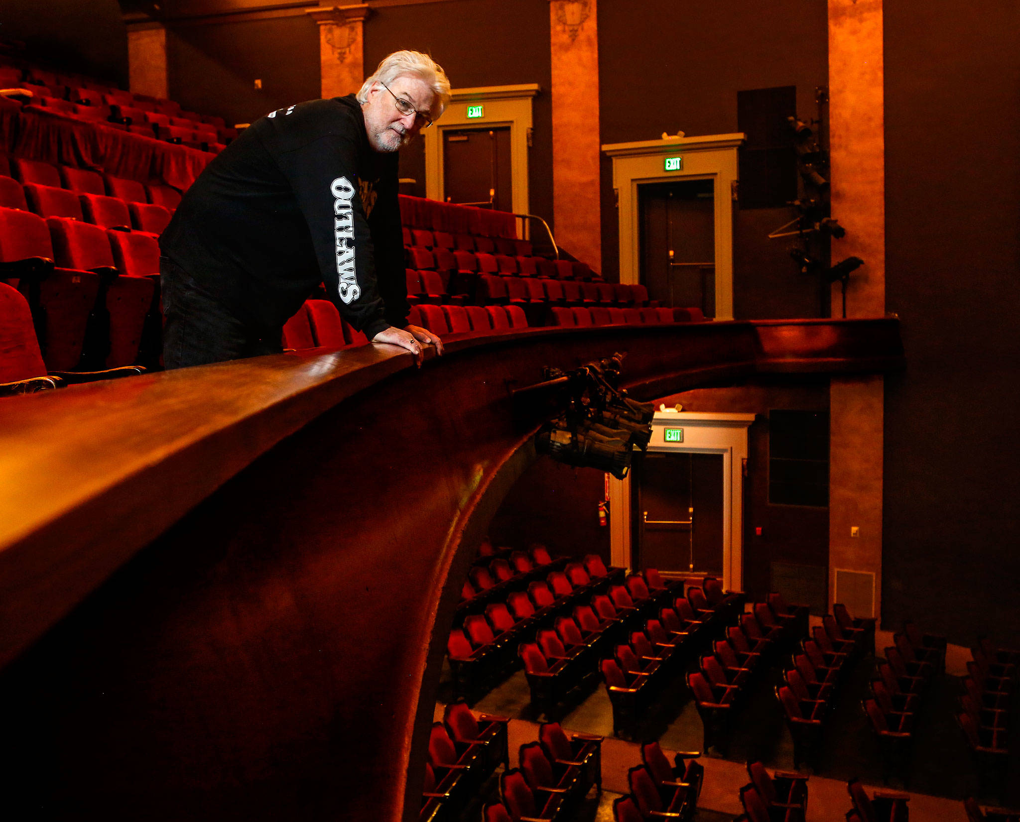 Curt Shriner looks out from behind the balcony rail in the Historic Everett Theatre, which he has operated since 2014. The 117-year-old theater, owned by his brother, Craig Shriner, is for sale with an asking price of $2,450,000. (Dan Bates / The Herald)