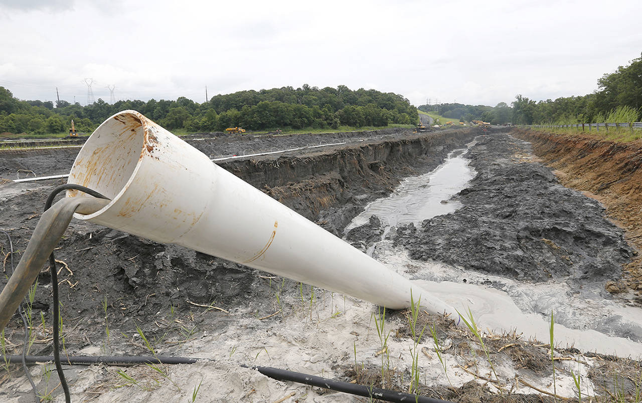 A drain pipe sticks out of a coal ash retention pond at the Dominion Power’s Possum Point Power Station in 2015 in Dumfries, Virginia. (AP Photo/Steve Helber, File)