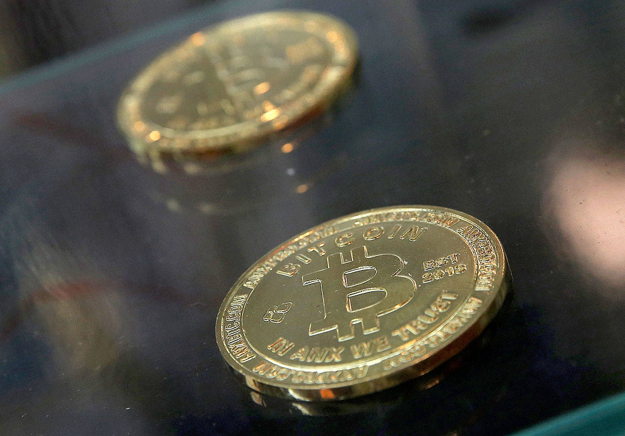 Coins are displayed next to a Bitcoin ATM in Hong Kong in December. (AP Photo/Kin Cheung)