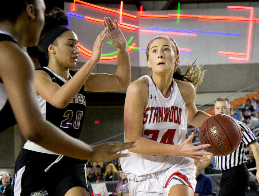 Stanwood’s Jillian Heichel drives the baseline with Garfield’s Niveya Henley defending during the semifinals of the 3A Hardwood Classic on March 2, 2018, at the Tacoma Dome. (Kevin Clark / The Herald)
