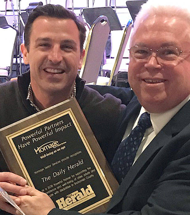 Daily Herald Publisher Josh O’Connor (left) accepts the Powerful Partners Award from Homage Senior Services CEO Steve McGraw.